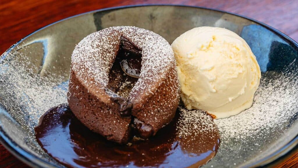 Chocolate volcano pudding with a scoop of ice cream on a plate